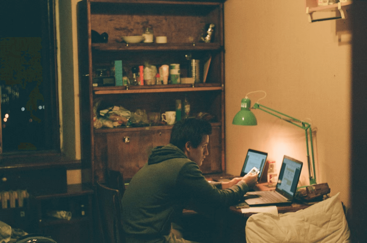 Man using two laptops for financial planning