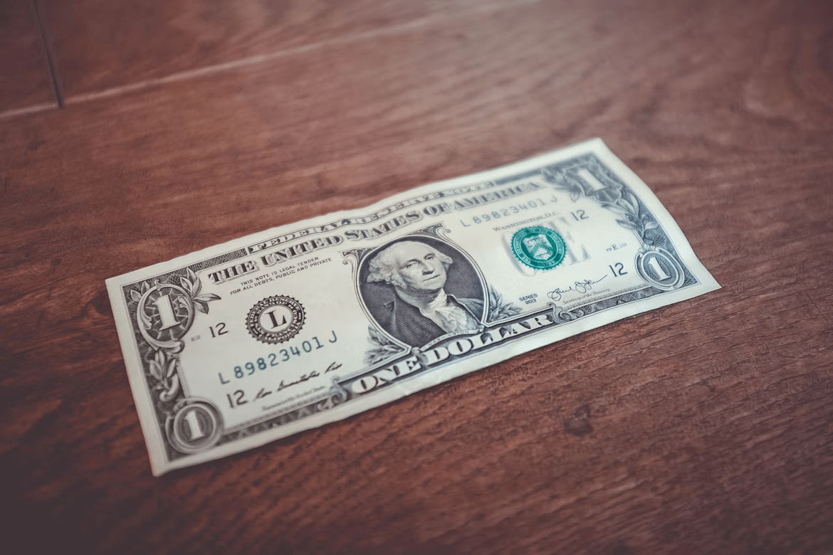 One dollar bill on wooden table